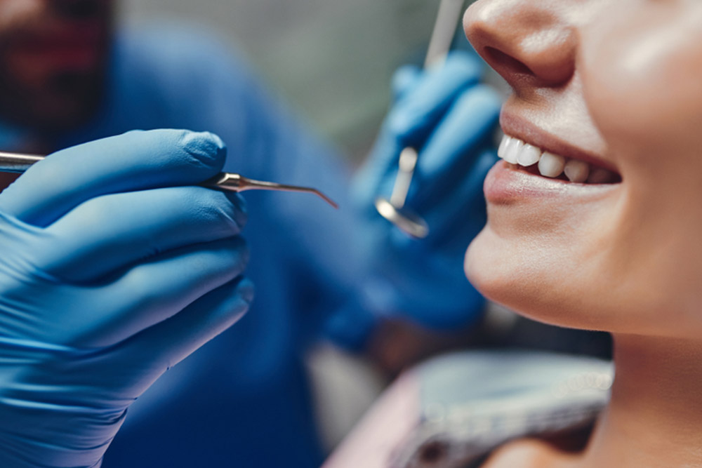 Attractive young woman in stomatology clinic with male dentist